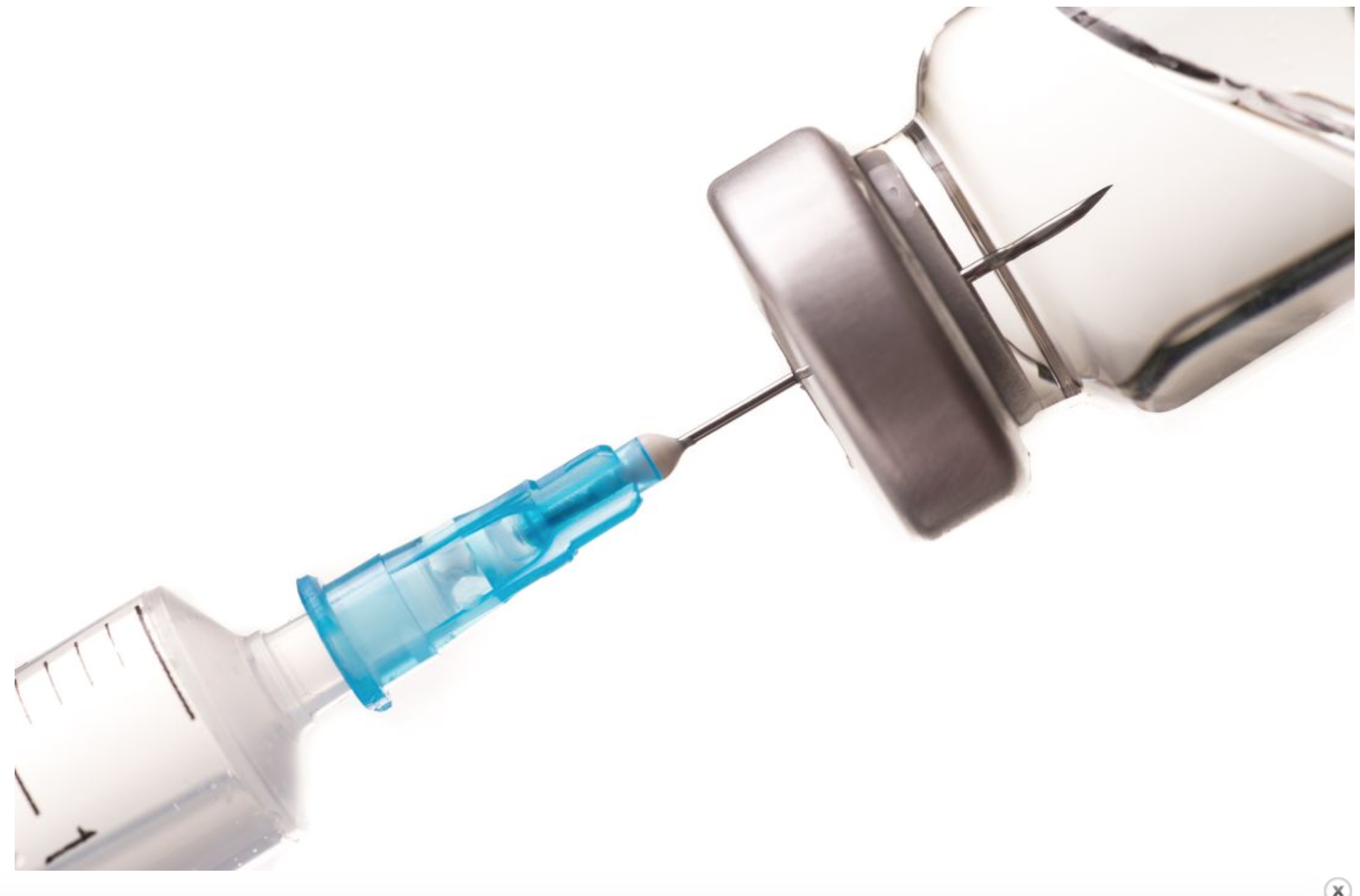 A syringe taking a dose of medicine in a vial